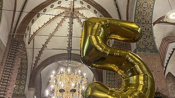 Gelungener Abend im Dom Eine aufblasbare Fünf aus goldener Folie im Schleswiger Dom