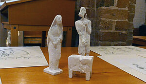 Drei Gipsfiguren zeigen Maria, Joseph und das Jesuskind in der Krippe
