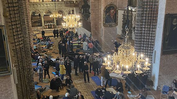Von Yoga bis Flohmarkt: Der Dom wurde zum offenen Raum Der Blick von oben auf das Innere des Schleswiger Doms mit vielen Menschen, die durcheinander liegen, gehen, stehen oder sitzen